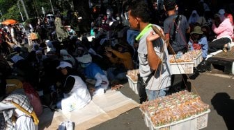 Sejumlah pedagang berjualan diantara massa yang berkumpul di kawasan Patung Kuda, Monas, Jakarta, Kamis (27/6). [Suara.com/Arief Hermawan P]