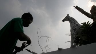 Pekerja menyelesaikan pembuatan kendaraan hias di kawasan Monas, Jakarta, Jumat (28/6). [Suara.com/Arief Hermawan P]