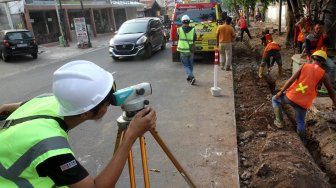 Pekerja menyelesaikan pengerjaan revitalisasi trotoar di kawasan Kemang, Jakarta Selatan, Sabtu (29/6).[Suara.com/Arief Hermawan P]