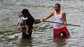 Sejumlah warga menikmati suasana sungai Ciliwung di kawasan Depok, Jawa Barat, Senin (1/7). [Suara.com/Arief Hermawan P]