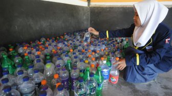 Seorang siswa menata botol bekas yang telah terkumpul saat pendaftaran peserta didik baru di SMP Negeri 1 Jogonalan, Klaten, Jawa Tengah, Selasa (2/7). [ANTARA FOTO/Aloysius Jarot Nugroho]