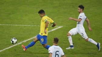 Penyerang Brasil Roberto Firmino dari Brasil menembak untuk mencetak gol melawan Argentina selama pertandingan semifinal Copa America di Stadion Estadio Mineirao, Brasil, Rabu (3/7). [MAURO PIMENTEL / AFP]