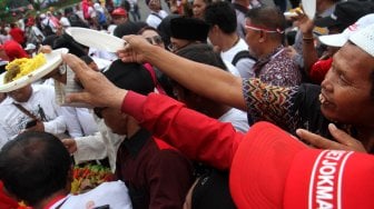 Sejumlah pendukung Presiden Terpilih Joko Widodo-Ma'ruf Amin yang tergabung dalam Relawan Indonesia Bersatu menggelar acara tumpengan di depan Istana Merdeka, Jakarta, Jumat (5/7). [Suara.com/Arief Hermawan P]