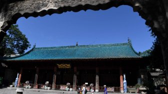 Seorang petugas masjid melintas di samping gerbang Masjid Raya Xi'an di Xi'an, Shaanxi, China, Sabtu (6/7). ANTARA FOTO/Zabur Karuru