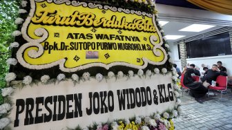 Sejumlah karangan bunga berdatangan ke rumah duka almarhum Sutopo Purwo Nugroho di kediamannya, Rafles Hills, Cimanggis, Depok, Minggu (7/7). [Suara.com/Muhaimin A Untung]