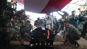 Petugas TNI dan BPBD menurunkan peti jenazah Kepala Pusat Data Informasi dan Humas Badan Nasional Penanggulangan Bencana (BNPB) Sutopo Purwo Nugroho ke dalam liang lahat saat pemakaman di Tempat Pemakaman Umum Sonolayu, Boyolali, Jawa Tengah, Senin (8/7). ANTARA FOTO/Aloysius Jarot Nugroho