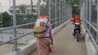 Pengendara motor mengambil jalan pintas melewati Jembatan Penyeberangan Orang (JPO) yang berada di atas ruas Tol Cinere-Jagorawi (Cijago), Kota Depok, Jawa Barat , Selasa (9/7). [ANTARA FOTO/Yulius Satria Wijaya]