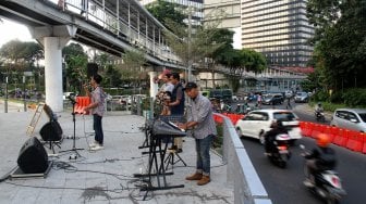 Sejumlah seniman tampil membawakan musik untuk menghibur warga yang melintas di area Taman Spot Budaya, Dukuh Atas, Jakarta, Jumat (12/7). [Suara.com/Arief Hermawan P]