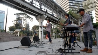 Sejumlah seniman tampil membawakan musik untuk menghibur warga yang melintas di area Taman Spot Budaya, Dukuh Atas, Jakarta, Jumat (12/7).[Suara.com/Arief Hermawan P]