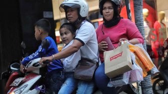 Warga membawa barang bawaan menggunakan tas plastik di Pasar Baru, Jakarta, Minggu (14/7). [Suara.com/Muhaimin A Untung]