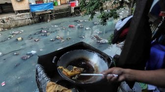 Warga beraktifitas di samping kali penuh sampai di kawasan kebon sirih, Jakarta, Minggu (14/7). [Suara.com/Muhaimin A Untung]