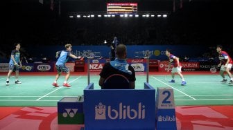 Pebulu tangkis ganda putra Indonesia Marcus Gideon dan Kevin Sanjaya saat bertanding melawan pebulu tangkis ganda putra Jepang Takuto Inoue dan Yuki Kaneko dalam babak pertama Blibli Indonesia Open 2019 di Istora Senayan, GBK, Jakarta, Selasa (16/7). [Suara.com/Arief Hermawan P]