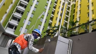 Seorang pekerja mengecat tembok taman di Rusun Pasar Rumput Jakarta, Kamis (18/7). ANTARA FOTO/Wahyu Putro A