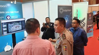 Kepala Divisi Humas Mabes Polri Irjen. Pol. Muhammad Iqbal (tegah) didampingi Managing Director PT Napindo Media Ashatama Arya Seta Wiriadipoera (batik biru) saat melakukan kunjungan salah satu stan berisi produk rescue & safety di perhelatan akbar pameran teknologi industri keamanan terbesar dan terlengkap di Indonesia, Indo Security 2019 Expo & Forum di Jakarta Convention Center, Jakarta, Kamis (19/7). [Suara.com/oke atmaja]
