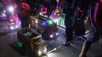 Peserta menarik miniatur truk berbahan baku kayu saat Festival Miniatur Truk di Kota Kediri, Jawa Timur, Sabtu (20/7) malam. ANTARA FOTO/Prasetia Fauzani