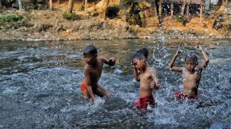 Sejumlah warga beraktivitas di bantaran Sungai Ciliwung, Jakarta, Jumat (19/7). [Suara.com/Muhaimin A Untung]