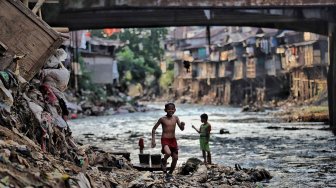 Sejumlah warga beraktivitas di bantaran Sungai Ciliwung, Jakarta, Jumat (19/7). [Suara.com/Muhaimin A Untung]