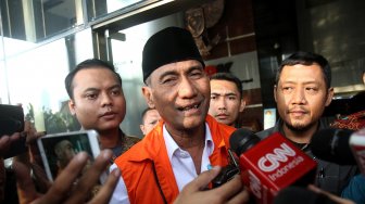 Bupati Kudus Muhammad Tamzil berjalan keluar menggunakan rompi tahanan usai menjalani pemeriksaan di gedung KPK, Jakarta, Sabtu (27/7). [Suara.com/Arief Hermawan P]