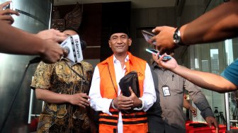 Bupati Kudus Muhammad Tamzil berjalan keluar menggunakan rompi tahanan usai menjalani pemeriksaan di gedung KPK, Jakarta, Sabtu (27/7). [Suara.com/Arief Hermawan P]