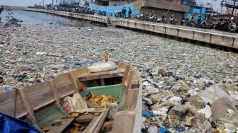 Tumpukan sampah menumpuk di pinggir laut kawasan Pelabuhan Muara Baru, Jakarta Utara, Senin (29/7).  [Suara.com/Oke Atmaja]