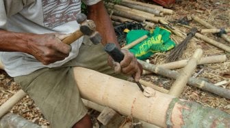 Pedagang menyelesaikan pohon pinang yang akan dijual di kawasan Manggarai, Jakarta, Rabu (31/7). [Suara.com/Oke Atmaja]