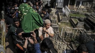 Kerabat membawa foto dan barbel selebriti almarhum Agung Santoso atau Agung Hercules saat akan dimakamkan di TPU Cikutra, Bandung, Jawa Barat, Jumat (2/8). [ANTARA FOTO/Novrian Arbi]
