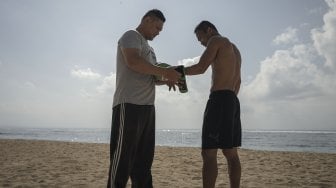 Petinju Indonesia yang juga pemegang gelar WBO Intercontinental kelas ringan (61,2 kilogram),  Daud Yordan menjalani sesi latihan di kawasan pantai Sanur, Bali, Selasa (30/7).  [Foto : Kurniawan Mas'ud untuk suara.com] 
