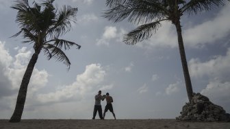 Petinju Indonesia yang juga pemegang gelar WBO Intercontinental kelas ringan (61,2 kilogram),  Daud Yordan menjalani sesi latihan di kawasan pantai Sanur, Bali, Selasa (30/7).  [Foto : Kurniawan Mas'ud untuk suara.com] 
