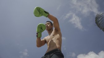 Petinju Indonesia yang juga pemegang gelar WBO Intercontinental kelas ringan (61,2 kilogram),  Daud Yordan menjalani sesi latihan di kawasan pantai Sanur, Bali, Selasa (30/7).  [Foto : Kurniawan Mas'ud untuk suara.com] 
