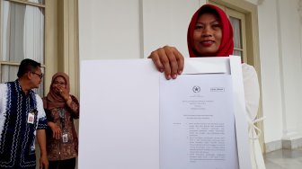 Penerima amnesti dari presiden, Baiq Nuril Maknun membawa salinan petikan Keppres amnesti usai bertemu dengan Presiden Joko Widodo di Istana Bogor, Jawa Barat, Jumat (2/8/). [Suara.com/Ummy Hadyah Saleh]

