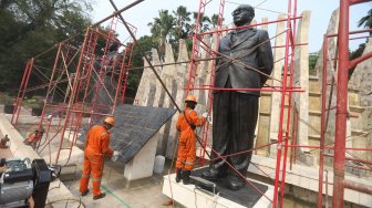 Petugas Dinas Pariwisata dan Kebudayaan Provinsi DKI Jakarta melakukan konservasi patung proklamator di Tugu Proklamasi, Jakarta, Kamis (8/8). [Suara.com/Arya Manggala]