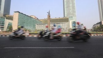 Kendaraan bermotor melintas saat CFD ditiadakan di kawasan Sudirman-Thamrin, Jakarta, Minggu (11/8). [Suara.com/Arya Manggala]