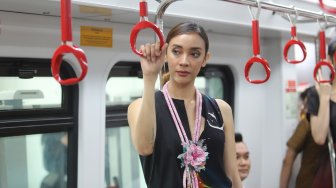 Model memperagakan busana dalam acara Jakarta Fashion & Food Festival (JFFF) 2019 di dalam gerbong LRT Jakarta jurusan Stasiun Velodrome menuju Stasiun Boulevard Utara, di Jakarta, Selasa (13/8). [Suara.com/Arya Manggala]
