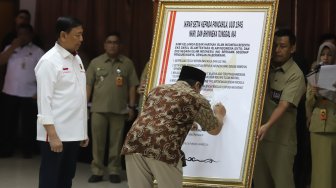 Keluarga besar Harokah Islam Indonesia, eks DI/TII dan eks NII menandatangani ikrar setia kepada Pancasila, UUD 1945, dan Bhinneka Tunggal Ika di Kantor Kemenko Polhukam, Jakarta, Selasa (13/8). [Suara.com/Arya Manggala]