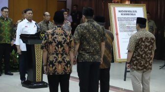 Keluarga besar Harokah Islam Indonesia, eks DI/TII dan eks NII membacakan ikrar setia kepada Pancasila, UUD 1945, dan Bhinneka Tunggal Ika di Kantor Kemenko Polhukam, Jakarta, Selasa (13/8). [Suara.com/Arya Manggala]