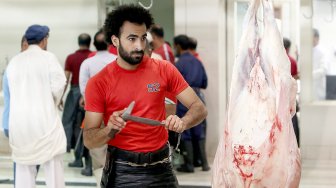 Mohammad Ibraheem saat memotong daging di sebuah rumah jagal hewan di hari ketiga Idul Adha di Kota Kuwait, Selasa (13/8). [AFP Photo/ Yasser Al-Zayyat]