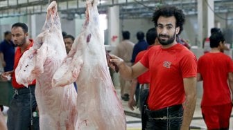 Mohammad Ibraheem saat memotong daging di sebuah rumah jagal hewan di hari ketiga Idul Adha di Kota Kuwait, Selasa (13/8). [AFP Photo/ Yasser Al-Zayyat]