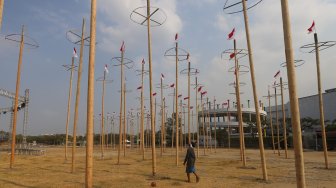 Pekerja memasang bendera merah putih pada pohon pinang untuk acara panjat pinang kolosal di kawasan Ancol, Jakarta, Rabu (14/8). [Suara.com/Arya Manggala]