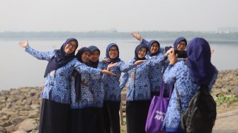 Sejumlah ASN (Aparatur Sipil Negara) Selfie di pinggir pantai usai mengikuti upacara peringatan hari kemerdekaan di Pulau D Reklamasi, Jakarta Utara, Sabtu (17/8). [Suara.com/Arya Manggala]