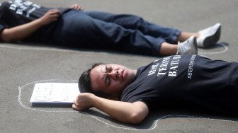 Sejumlah aktivis melakukan aksi berbaring #Bersihkan Indonesia di depan Istana Merdeka, Jakarta, Senin (19/8). [Suara.com/Arya Manggala]