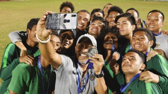 Pelatih Timnas U-18 Indonesia Fakhri Husaini (tengah) melakukan foto bersama dengan pemainnya saat penyerahan medali Piala AFF U-18 di Stadion Thong Nhat Ho Chi Minh, Vietnam, Senin (19/8). [ANTARA FOTO/Yusran Uccang]