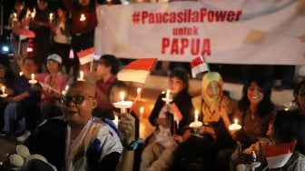 Massa yang tergabung dalam Pencinta NKRI dan Pancasila menggelar doa bersama untuk Papua di Tugu Proklamasi, Menteng, Jakarta, Selasa (20/8) malam. [Suara.com/Arya Manggala]