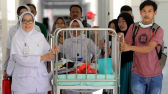 Petugas medis membawa Aqila ke Instalansi Rawat Inap (Irna) anak RSUD Dr Soetomo Surabaya, Jawa Timur, Selasa (20/8). [ANTARA FOTO/Didik Suhartono]