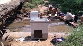 Gokil, Emak-emak Ini Nyuci Baju di Sungai Bawa Mesin Cuci