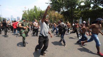 Sejumlah pemuda dan mahasiswa asal Papua terlibat saling dorong dengan aparat keamanan saat melakukan aksi unjuk rasa di kawasan Monas, Jakarta, Kamis (22/8). [Suara.com/Arya Manggala]