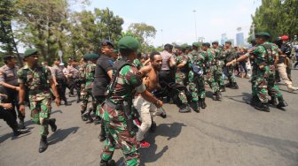 Sejumlah pemuda dan mahasiswa asal Papua terlibat saling dorong dengan aparat keamanan saat melakukan aksi unjuk rasa di kawasan Monas, Jakarta, Kamis (22/8). [Suara.com/Arya Manggala]