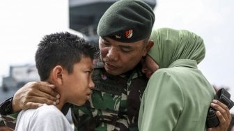 Seorang prajurit TNI AD dari Batalyon Infanteri Raider 142/Ksatria Jaya berbincang dengan anak dan istrinya usai mengikuti upacara pemberangkatan Satgas Pamtas RI-RDTL Sektor Timur di Pelabuhan Boom Baru Palembang, Sumatera Selatan, Rabu (28/8). [ANTARA FOTO/Nova Wahyudi]