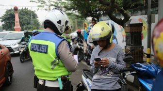 Petugas kepolisian memeriksa kelengkapan dokumen saat Operasi Patuh Jaya 2019 di Jalan Kemanggisan, Jakarta, Kamis (29/8). [Suara.com/Arya Manggala]