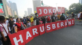 Sejumlah aktivis Koalisi Masyarakat Sipil melakukan aksi dengan membentangkan tulisan 'Jokowi Harus Berani' pada saat acara Car Free Day, Jakarta, Minggu (1/9/2019). [Suara.com/Arya Manggala]