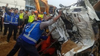 Petugas mengevakuasi salah satu kendaraan yang terlibat pada kecelakaan beruntun di Tol Cipularang KM 92 Purwakarta, Jawa Barat, Senin (2/9). [ANTARA FOTO/Ibnu Chazar]